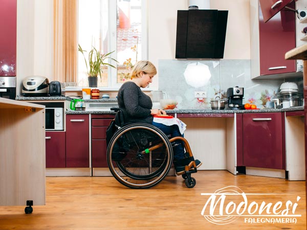 Arredamento per disabili Milano: donna disabile facendo un'insalata in cucina